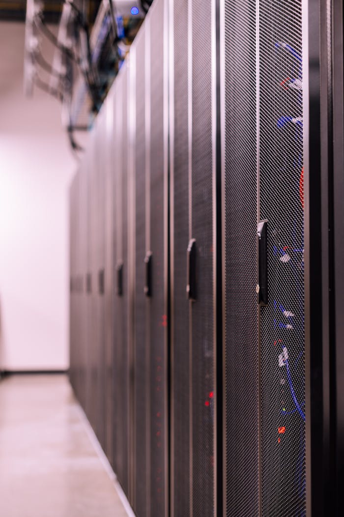 Row of similar lockers with various optic fiber cables in modern data server room